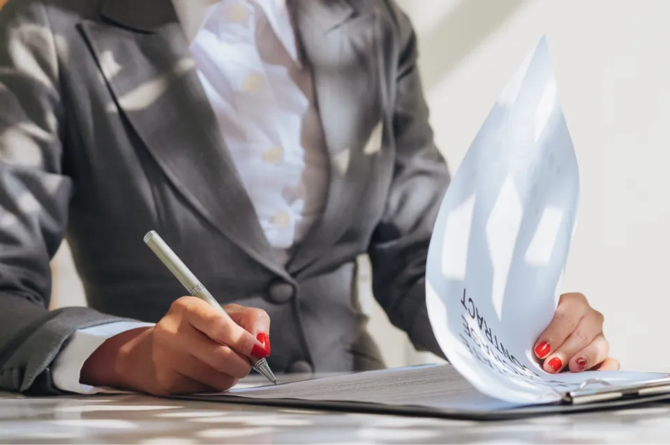 Personne relisant et signant des documents patrimoniaux